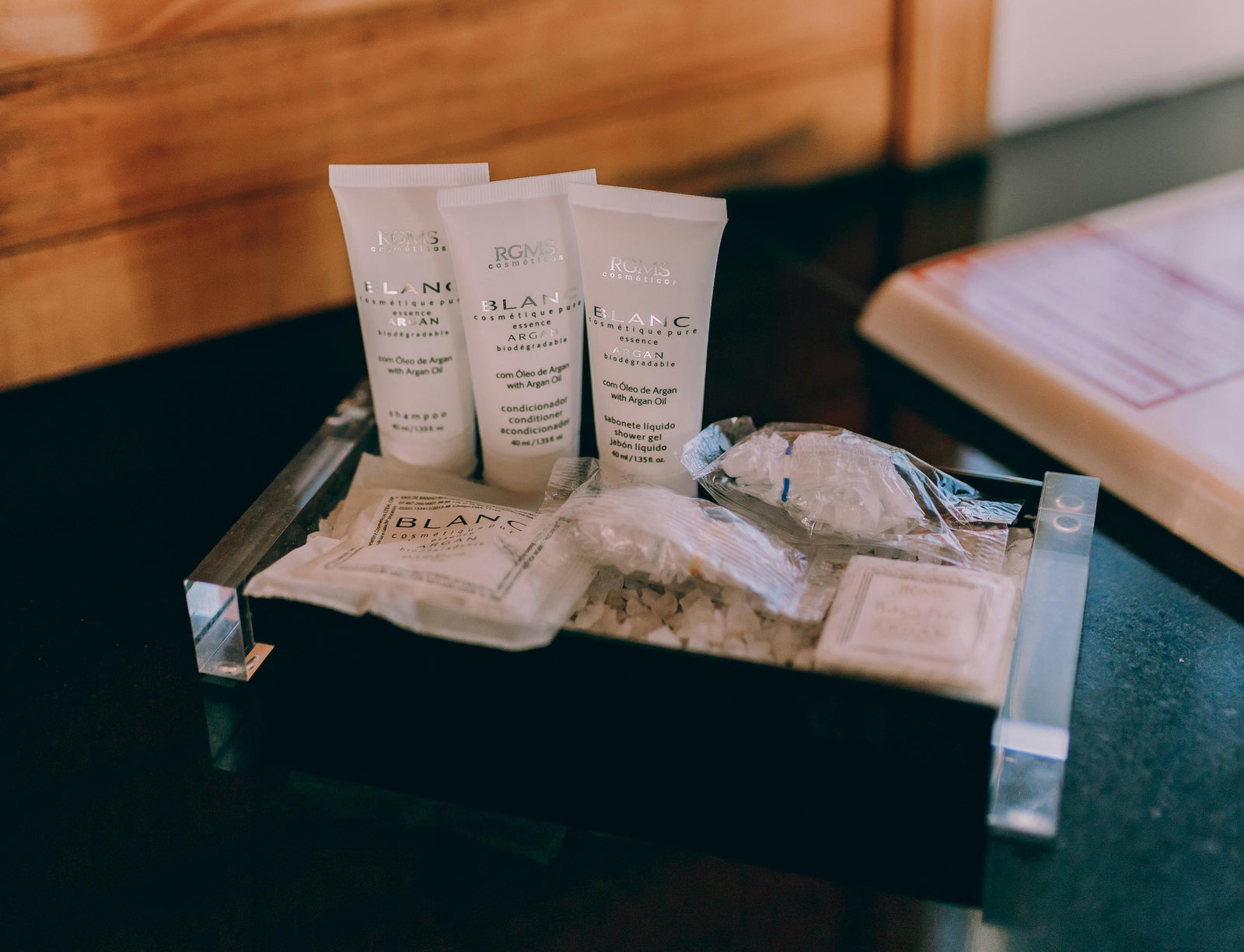 Mini shampoo bottles on countertop. Ban on single-use plastic toiletries in US hotels. Biodegradable shampoo, conditioner, body wash, hand soap tablets.