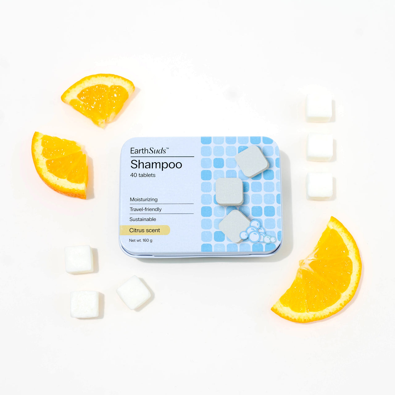 Travel shampoo in case with dissolvable shampoo tablets and oranges around it.