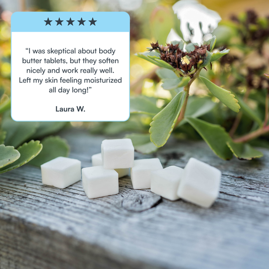 Body butter tablets for travel on a wooden surface with greenery in the background and a customer review overlay.